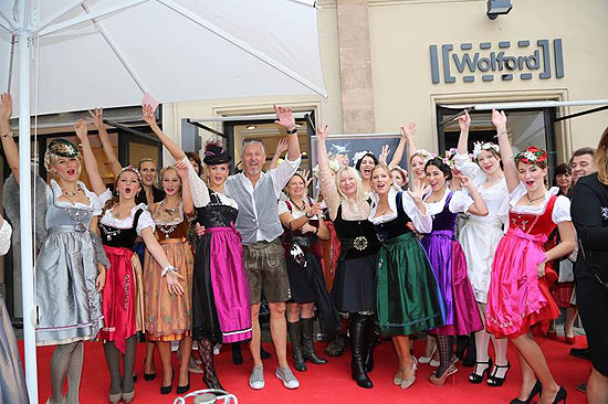 Samtherz Designerin Monika Strobl Klein (ganz in schwarz), Moderatorin des Abends Lilian Thau (mit schwarzem Hut) und Samtherz Manager Ulrich Höcker  inmitten der Samtherz Dirndlentwürfe und Models vor der Wolford Boutique in der Maximilianstraße.